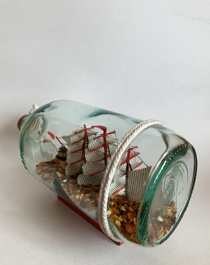 Laivas butelyje su gintaro gabalėliais